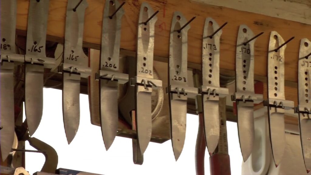 A rack of Loveless knife blade blanks hanging on the shop wall